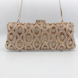 Detail of gold evening clutch bag featuring intricate hollow metal work and crystal rhinestones