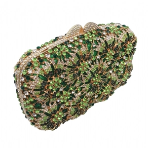 Close-up of luxury floral hollow clutch with green and yellow rhinestones and gold frame