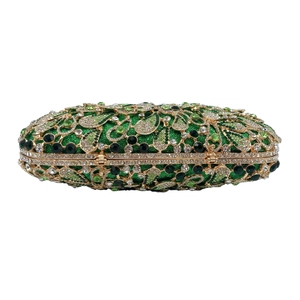 Macro detail of luxury evening clutch with green rhinestones and floral metal frame