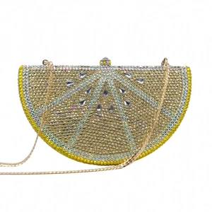 Close-up of lemon-shaped evening clutch with sparkling champagne and yellow rhinestones