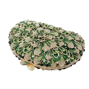 Macro shot of green rhinestones and hollow gold metal frame on an evening clutch bag