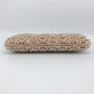 Detailed close-up of hollow gold metal evening clutch with shimmering rhinestones