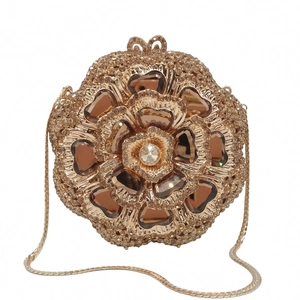 Macro detail of golden flower evening bag with crystals and heart-shaped amber petals