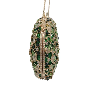 Close-up of green rhinestone evening bag with gold hollow metal work and chain strap