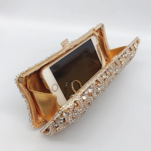Detailed top view of a rhinestone dinner clutch showing spacious gold interior and phone fit