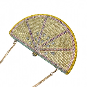 Detailed view of lemon-shaped evening clutch bag with crystals and gold flat chain strap