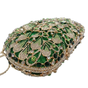 Macro detail of luxury emerald rhinestone clutch with gold filigree and crystals