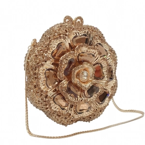 Macro detail of hollow metal evening clutch featuring heart-shaped gems and floral crystals