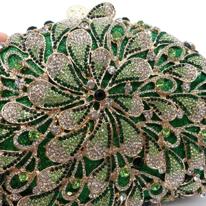 Macro detail of emerald green rhinestones and golden metal floral pattern on dinner clutch