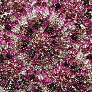 Macro detail of rose red evening bag with multi-color rhinestones in floral pattern