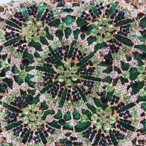 Macro detail of emerald green hollowed evening clutch with rhinestones and floral patterns