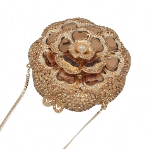 Macro detail of floral evening clutch bag with champagne crystals and golden snake chain