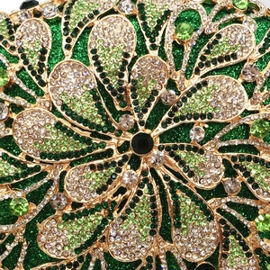 Macro detail of golden metal filigree frame with emerald and black rhinestones