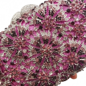 Detailed macro view of handcrafted floral rhinestone pattern on pink evening clutch bag