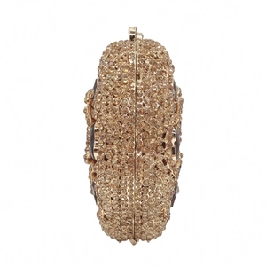 Detail of champagne gold evening clutch featuring full rhinestones and side gemstone accents