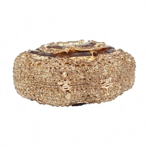Detailed close-up of golden evening clutch with hollow rhinestones and floral amber stone