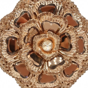 Macro shot of rose gold floral clutch details with champagne rhinestones and dark crystals