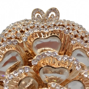 Macro detail of gold heart-shaped clutch bag with luxury crystal rhinestones