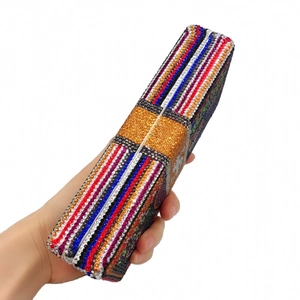 Détail d'une pochette de soirée avec motifs complexes en strass inspirés du billet de dollar