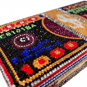Détail macro d'une pochette de soirée en cristaux avec motif billet de dollar