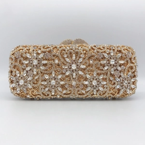 Detail of golden evening clutch featuring floral rhinestone patterns and heart clasp