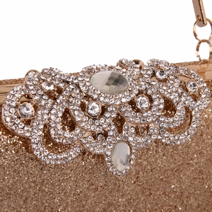 Detailed close-up of vintage gold floral metalwork and crystals on a sparkling evening bag