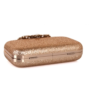 Detailed macro of a luxury champagne gold sequins evening clutch bag with ornate metal clasp