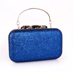 Macro shot of royal blue sequins and ornate gold clasp with rhinestones on party clutch