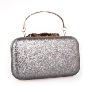 Detail of silver sequin evening clutch bag showing glitter texture and diamond clasp