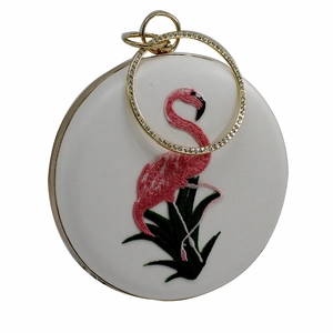 Gedetailleerd borduurwerk van roze flamingo en groene planten op witte avondtas