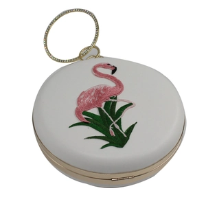 Detail van luxe witte ronde avondtas met roze flamingo borduursel en strass-ring