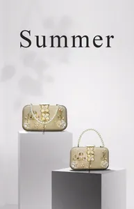 Détail du sac de soirée avec paillettes dorées, perles et ornements floraux en métal