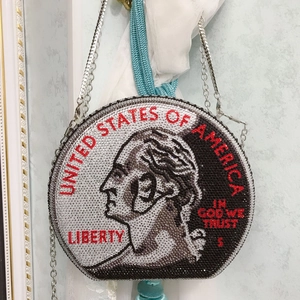 Macro shot of the 25 cents coin design featuring red and black rhinestones on a round clutch