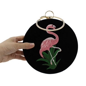 Detail van fluwelen avondtas met flamingo-borduurwerk en kristallen ringhandvat