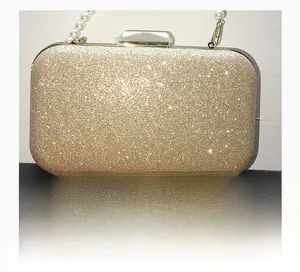 Détail d'une pochette dorée de soirée avec paillettes diamantées et poignée en perles