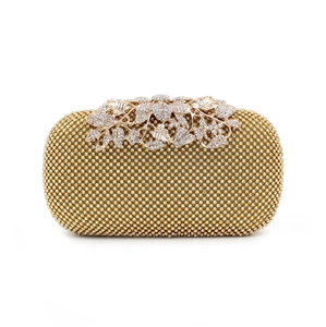 Detailed close-up of champagne gold evening clutch with floral leaf rhinestone clasp