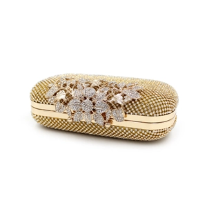 Detailed view of the sparkling floral crystal clasp on the gold evening clutch bag