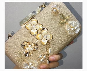 Détail d'une pochette de soirée dorée avec fleurs 3D en perles et franges
