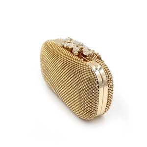 Detail of golden crystal clutch with butterfly-shaped diamond buckle clasp and sparkling rhinestones