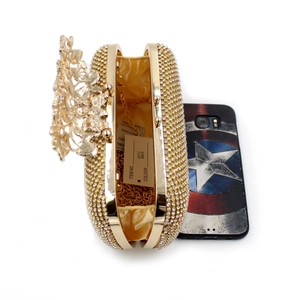 Macro shot of gold rhinestone evening clutch interior with metal chain and tag