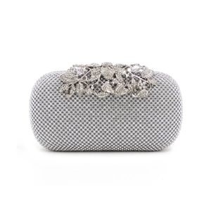 Macro detail of silver leaf clasp and crystal rhinestone texture on evening clutch bag