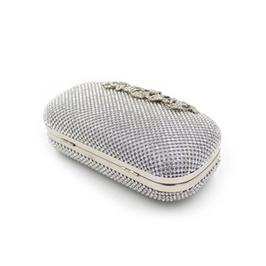 Detailed macro of the silver rhinestone evening clutch with ornate metal floral clasp