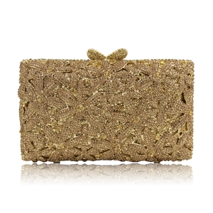 Close-up of golden evening clutch featuring butterfly clasp and sparkling rhinestones