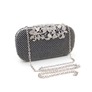 Detail of leaf buckle and sparkling crystals on a black evening clutch with chain