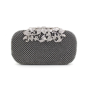 Macro detail of silver floral leaf clasp on black rhinestone evening clutch bag
