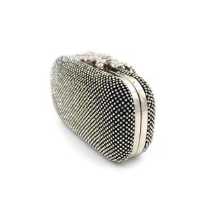 Close-up of evening clutch bag featuring black and white crystals with metallic frame