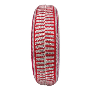 Detailed side view of round clutch bag with red and white striped rhinestones