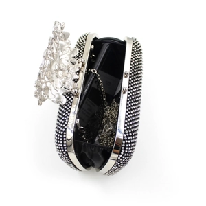 Detailed interior of a black rhinestone clutch showing space for a smartphone and chain