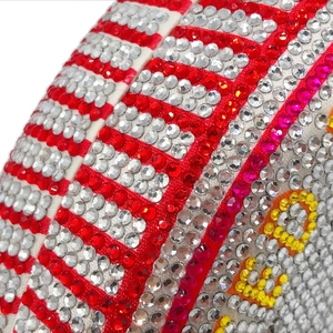 Macro shot of red and white rhinestones on a spherical dollar-themed evening clutch