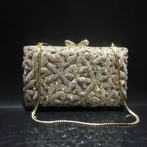 Detail of crystal evening clutch with hollow floral pattern and butterfly clasp
